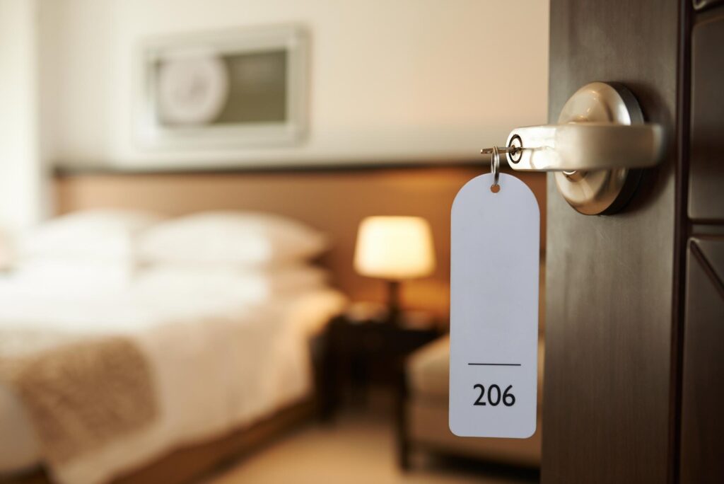 Geöffnete Tür eines Hotelzimmers mit Schlüssel im Schloss