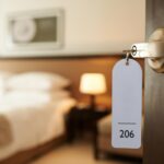 Geöffnete Tür eines Hotelzimmers mit Schlüssel im Schloss
