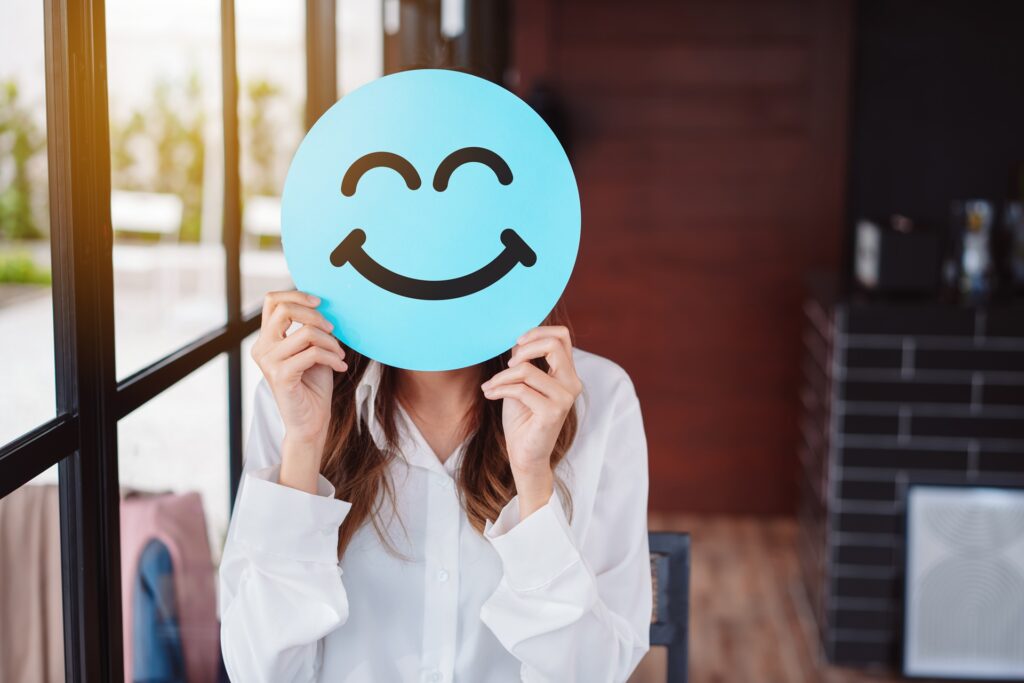 Frau mit lächelndem Smiley-Schild | Life Coach Berlin
